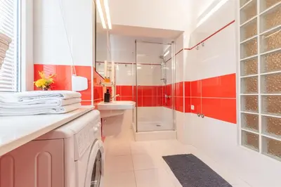 a red and white bathroom with a washing machine at Cozy apartment - Bosacka 10 street in Kraków