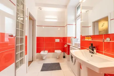 a red bathroom with a toilet and a sink at Cozy apartment - Bosacka 10 street in Kraków