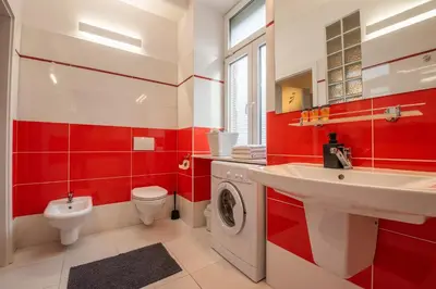 a red and white bathroom with a toilet and a sink at Cozy apartment - Bosacka 10 street in Kraków