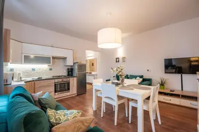 a kitchen and living room with a table and chairs at Cozy apartment - Bosacka 10 street in Kraków