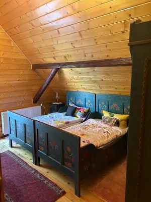 a bed in a room with a wooden ceiling at Rancho w Dolinie in Skomielna Biała
