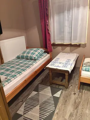 a bedroom with a bed and a bench and a window at Rancho w Dolinie in Skomielna Biała