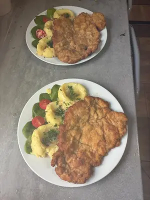 two plates of food with chicken and vegetables on a table at Rancho w Dolinie in Skomielna Biała