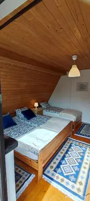 two beds in a room with wooden ceilings at Kwatery U Adama Zawoja in Zawoja