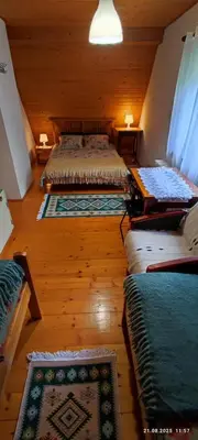 a bedroom with two beds and several rugs on the floor at Kwatery U Adama Zawoja in Zawoja
