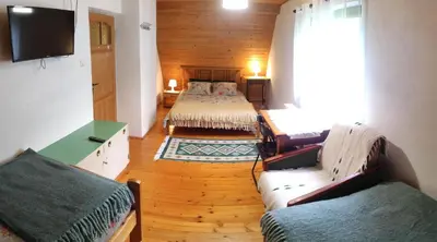 a room with two beds and a couch and a television at Kwatery U Adama Zawoja in Zawoja