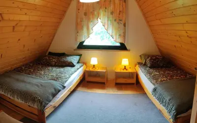 two beds in a small room with two lamps at Kwatery U Adama Zawoja in Zawoja