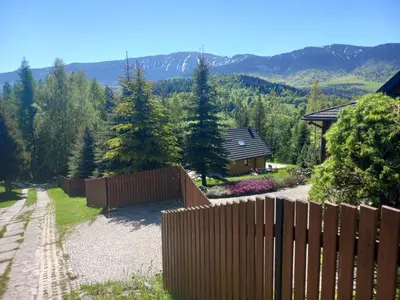 a wooden fence in front of a yard with a house at Kwatery U Adama Zawoja in Zawoja