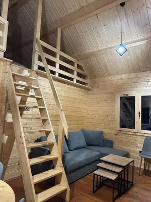 a living room with a blue couch and a ladder at Piekielne zacisze in Klecza Dolna