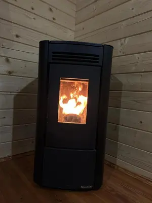 a black stove with a fire in a room at Piekielne zacisze in Klecza Dolna