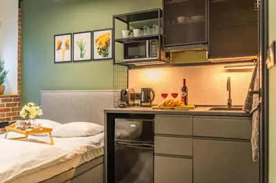 a small kitchen with a bed in a room at Kraków Grzegórzki Studio - Central Station Nearby - by Rentujemy in Kraków
