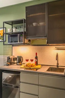 a kitchen with two wine glasses on a counter at Kraków Grzegórzki Studio - Central Station Nearby - by Rentujemy in Kraków