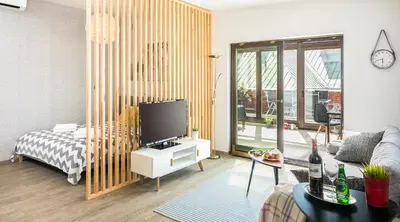 a living room with a bed and a tv in it at 7 Koron - Exclusive Apartments in Kraków
