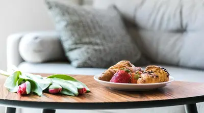 a table with a plate of food and strawberries on it at 7 Koron - Exclusive Apartments in Kraków