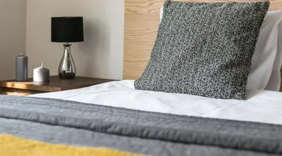 a close up of a bed with a pillow on it at 7 Koron - Exclusive Apartments in Kraków