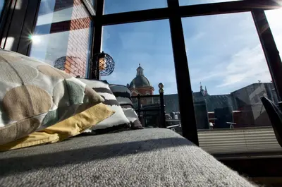a bedroom with a view of the city through a window at 7 Koron - Exclusive Apartments in Kraków