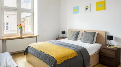 a bedroom with a large bed and a window at 7 Koron - Exclusive Apartments in Kraków