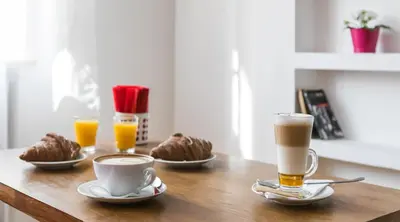 a table with two cups of coffee and two drinks at 7 Koron - Exclusive Apartments in Kraków