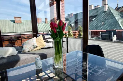 a vase of flowers sitting on a glass table at 7 Koron - Exclusive Apartments in Kraków