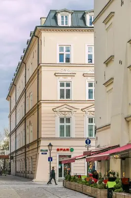 a man walking down a street in front of a building at 7 Koron - Exclusive Apartments in Kraków