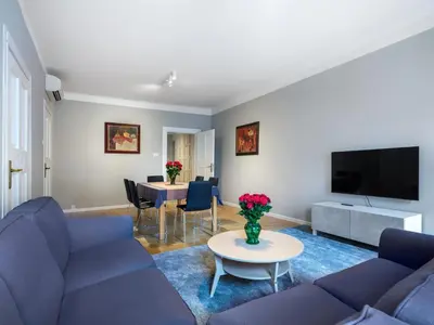 a living room with a blue couch and a table at Apartments Rynek Glowny in Kraków