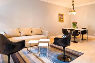a living room with a couch and chairs and a table at Apartments Rynek Glowny in Kraków