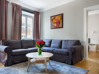a living room with a blue couch and a table at Apartments Rynek Glowny in Kraków
