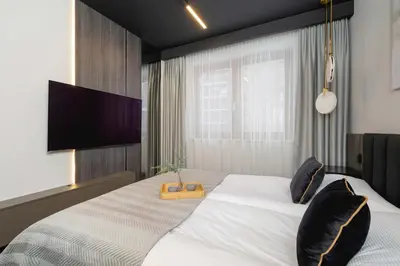 a bedroom with a large bed and a flat screen tv at Exclusive Apartment with Parking by Renters Prestige in Kraków