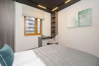 a bedroom with a bed and a desk and a window at Exclusive Apartment with Parking by Renters Prestige in Kraków