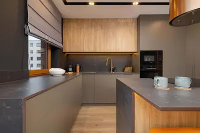 a kitchen with wooden cabinets and a counter top at Exclusive Apartment with Parking by Renters Prestige in Kraków