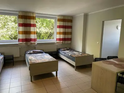 a room with two beds and a window at Noclegi Eliza in Dąbrowa Górnicza