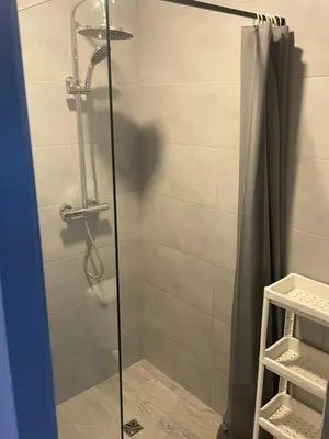 a bathroom with a shower with a glass door at Noclegi Eliza in Dąbrowa Górnicza