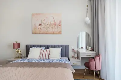 a bedroom with a bed and a pink chair at Apartment Blue near Schindler in Kraków