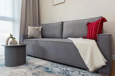 a gray couch with pillows on it in a living room at Apartment Blue near Schindler in Kraków