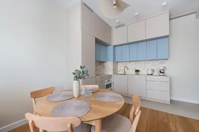 a kitchen with a wooden table and chairs at Apartment Blue near Schindler in Kraków