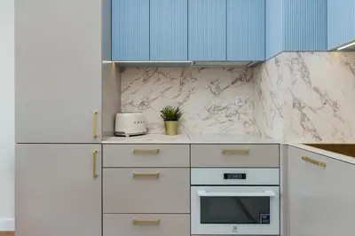 a kitchen with white appliances and blue cabinets at Apartment Blue near Schindler in Kraków