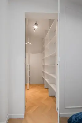a room with a closet with white shelves at Metropolis Design Apartments in Kraków