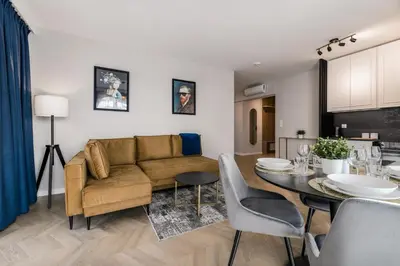 a living room and dining room with a couch and a table at Metropolis Design Apartments in Kraków