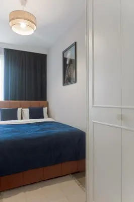 a bedroom with a bed with a blue comforter at Metropolis Design Apartments in Kraków