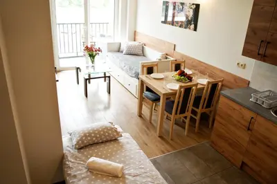 a small apartment with a bed and a table and a kitchen at Apartamenty Galicja Zator in Zator