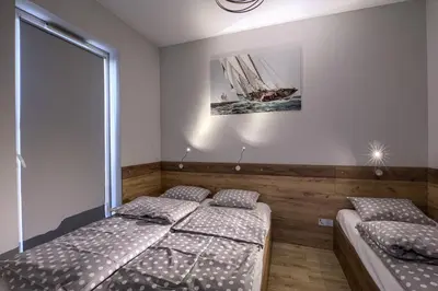 a bedroom with two beds and a picture of a ship at Apartamenty Galicja Zator in Zator