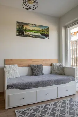 a bed in a white room with a large window at Apartamenty Galicja Zator in Zator
