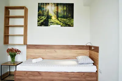 a bed in a room with a picture on the wall at Apartamenty Galicja Zator in Zator