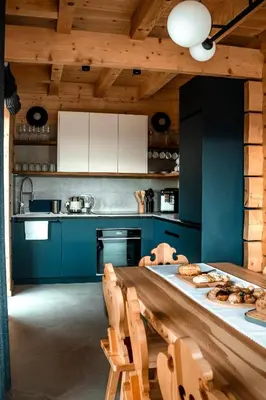 a kitchen with blue cabinets and a table with chairs at Makowy Zakątek in Maków Podhalański