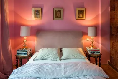 a bedroom with a bed with two lamps and books at Charming and stylish apartment in Kraków