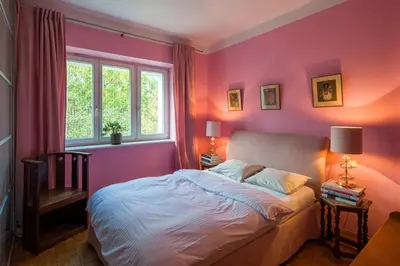 a bedroom with pink walls and a bed and a window at Charming and stylish apartment in Kraków