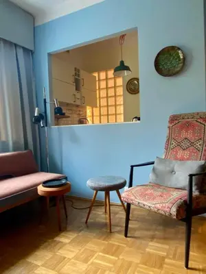a living room with a chair and a mirror at Charming and stylish apartment in Kraków