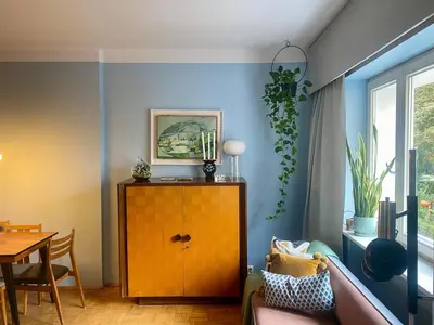 a living room with blue walls and a wooden cabinet at Charming and stylish apartment in Kraków