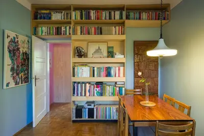 a dining room with a table and a book shelf with books at Charming and stylish apartment in Kraków