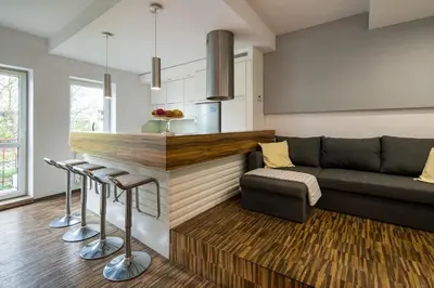 a living room with a couch and a kitchen at Comfort Apartment in great location in Kraków